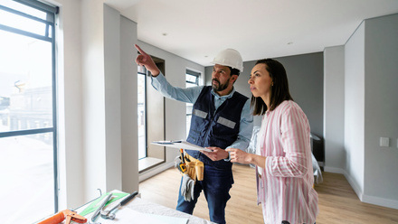Builder talking to client in home over plans.jpg