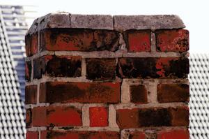 Crumbling chimney stack with water ingress