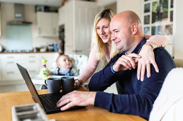 Couple searching for a builder online in their kitchen