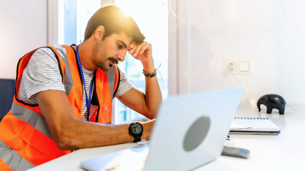 Stressed builder at laptop - cashflow and financial pressure.jpg
