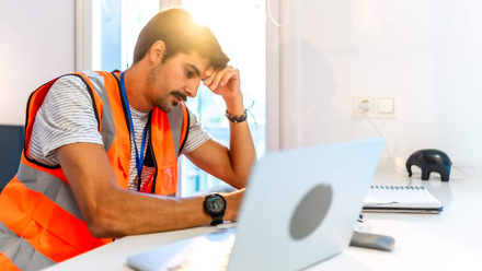 Stressed builder at laptop - cashflow and financial pressure.jpg
